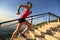 Healthy lifestyle sports woman running up on stone stairs sunrise