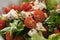 Healthy light salad with cherry tomatoes, mozzarella and frisee in white bowl closeup