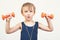 Healthy little boy working out with dumbbells over white background. Healthy lifestyle, kids sports and childhood. Cute kid boy ex