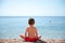 Healthy little child sitting on sea shore beach watching at horizon meditation