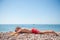 Healthy little kid in red shorts lying on summer beach during vacation tour