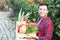 Healthy looking farmer holding a box of veggies