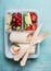 Healthy lunch box with salmon tortilla wraps and wooden cutlery , fruits and vegetables