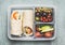 Healthy lunch box with vegetarian tortilla wraps, chopped vegetables and fruits on wooden background