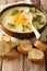 Healthy lunch broccoli cheese soup in a bowl with toast close-up. vertical