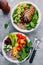 Healthy lunch Buddha bowls. Avocado, quinoa, red beans, spinach, avocado and fresh vegetables and with grilled chicken and grilled