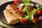 Healthy lunch: fried hake with tomato, radish and lettuce salad