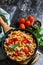 Healthy lunch. Fusilli pasta with canned tuna, grilled red peppers and tomatoes in frying pan.