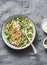 Healthy lunch -  orzo, green peas, spring herbs risotto and grilled chicken breast on a gray background