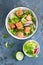 Healthy lunch salad with baked salmon fish, fresh radish, lettuce and lime