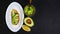 Healthy lunch snack, three delicious avocado sandwiches, fresh sliced avocados, on an plate, copy space on a black stone backgroun