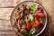 Healthy lunch: tender beef with vegetable salad close-up on a pl