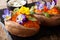 Healthy lunch of whole baked sweet potato with edible flowers is served with a sauce on the board. horizontal