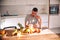 Healthy man carefully selecting and cutting the fruits for his smoothie