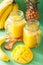 Healthy mango pineapple smoothie in mason jars