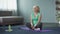 Healthy mature female doing fitness exercises on yoga mat, training at home