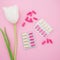 Healthy medical composition with vitamins and white flowers on pink background. Flat lay, top view