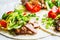 Healthy mini tortillas with grilled chicken, meat, fresh vegetables  on light grey background