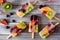 Healthy mixed fruit summer ice pops, above view over wood