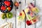 Healthy mixed fruit summer popsicles, table scene over white wood