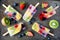 Healthy mixed fruit summer popsicles, top view on a dark background