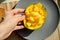 Healthy morning breakfast. Hand holds a mango. Bright yellow mango in a plate. Exotic fruits on a plate. Healthy diet. Gray plate.