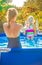 Healthy mother and child in swimsuit in swimming pool playing