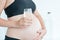 Healthy mother to be holding a glass of water in front of her belly