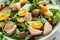 Healthy Nicoise salad with salmon, colourful sweet cherry tomatoes, olives, green beans, cucumber ribbons, soft boiled