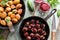 Healthy Nordic cuisine. Fried potatoes, meatballs with berry sauce in cast iron pans and lingonberry drink on rustic blue table