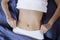 Healthy nutrition and belly health concept. Close up of woman flat stomach. Girl in bed with hungry feeling. Top view