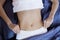 Healthy nutrition and belly health concept. Close up of woman flat stomach. Girl in bed with hungry feeling. Top view. Banner