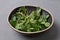 Healthy nutrition concept, sprouted sunflower microgreens in a bowl on a gray background, vegetarian food