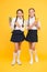 Healthy nutrition. Schoolgirls holding juice bottle on yellow background. Quenching thirst during school time. Thirst