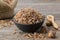 Healthy oak bark in black bowl and acorns on wooden table. Herbal medicine