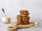 Healthy oatmeal cookies with dates, nuts and flaxseed on a wooden board on a gray textured background. Delicious