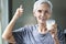 Healthy old elderly grandmother thumbs up for delicious fresh milk drink during breakfast,happy smiling asian senior woman