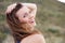 Healthy older woman smiling outside with hand in hair