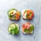 Healthy open sandwiches with vegetables, salmon, ham, herbs and soft cheese.