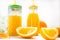 Healthy orange juice in a glass jar and a bottle stands on a white background. In the foreground are two slices of juicy orange.