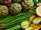 Healthy organic food background. Artichokes, asparagus and zuccini with flowers. Top view