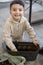 Healthy organic food concept. Child putting soil in flower pot.