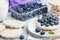 Healthy organic rice cakes with ricotta and fresh blueberries and glass of milk on light stone kitchen background. Top view.