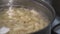 Healthy pasta cooked in a metal pan in water on a gas stove close-up