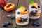 Healthy peach and blueberry parfPeach and blueberry parfaits in mason jars agaiaits in mason jars against a rustic wood background