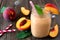 Healthy peach smoothie in a mason jar glass, close up against a wood background