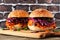 Healthy, plant based meatless pulled carrot burgers against a dark brick background