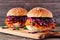 Healthy, plant based meatless pulled carrot burgers against a wood background