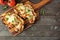 Healthy plant-based vegetarian cauliflower parmesan, top view on a serving board over rustic wood