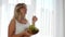 Healthy pregnancy, pregnant female with big naked tummy eats grapes and holds wooden plate with fruits
